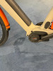 Detail eines E-Bikes mit Bosch-Motor und orangefarbenem Schutzblech.