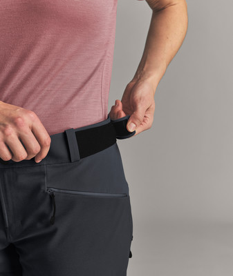 Eine Frau schließt den Klettverschluss an ihrer Hose über der Tasche. Eine Frau schließt den Klettverschluss an ihrer Hose über der Tasche.