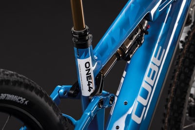 Nahaufnahme eines blauen Mountainbikes mit Dämpfer und CUBE-Logo.