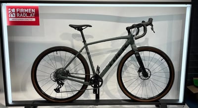 Graues Trek Gravelbike mit braunen Reifen auf einem Ständer. Graues Trek Gravelbike mit braunen Reifen auf einem Ständer.