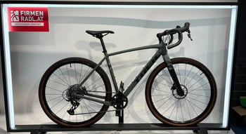 Graues Trek Gravelbike mit braunen Reifen auf einem Ständer.