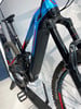 Ein blau-rotes E-Bike mit Federung und breiten Reifen.
