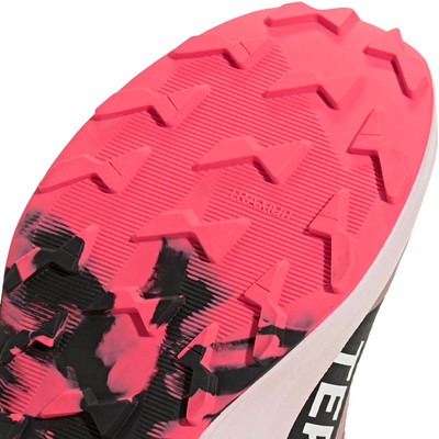 Eine pinke Sohle mit schwarzen und weißen Mustern und dem Aufdruck TRAXION. Eine pinke Sohle mit schwarzen und weißen Mustern und dem Aufdruck TRAXION.
