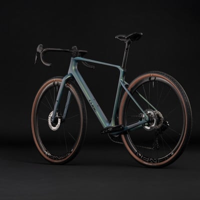 Modernes Gravelbike mit glänzendem Rahmen und braunen Reifen vor schwarzem Hintergrund. Modernes Gravelbike mit glänzendem Rahmen und braunen Reifen vor schwarzem Hintergrund.