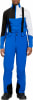 Ein Mann in blauer Skihose mit Hosenträgern und farbiger Jacke.
