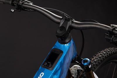 Detail eines E-Bikes mit blauem Rahmen, Display und Fox-Lenker.