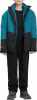 Junge in einer blau-schwarzen Jacke und schwarzer Hose mit Turnschuhen.