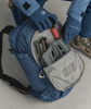 Blaue ORTOVOX Jacke und Handschuhe, blauer Rucksack mit Ausrüstung darin.