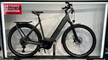 Graues Cube E-Bike mit Gepäckträger und Schutzblechen im Geschäft.