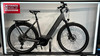 Graues Cube E-Bike mit Gepäckträger und Schutzblechen im Geschäft.