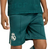 Ein Kind trägt dunkelgrüne Shorts mit dem weißen Real Madrid-Logo und Streifen an den Seiten.