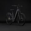 Graues Cube E-Bike mit Gepäckträger und Federung vor schwarzem Hintergrund.