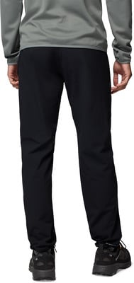 Ein Mann in schwarzer Hose und grauem Oberteil steht vor weißem Hintergrund. Ein Mann in schwarzer Hose und grauem Oberteil steht vor weißem Hintergrund.