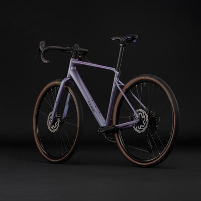 Lila Cube Gravelbike mit braunen Reifen vor schwarzem Hintergrund. Lila Cube Gravelbike mit braunen Reifen vor schwarzem Hintergrund.
