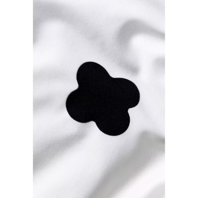 Vierblättriges Kleeblatt aus schwarzem Stoff auf weißem Hintergrund. Vierblättriges Kleeblatt aus schwarzem Stoff auf weißem Hintergrund.