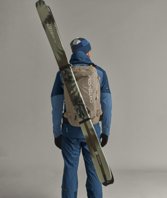 Ein Mann mit einem Rucksack und Skiern auf dem Rücken