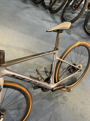 Ein graues Fahrrad mit braunen Reifen steht auf einem blauen Teppich. Ein graues Fahrrad mit braunen Reifen steht auf einem blauen Teppich.