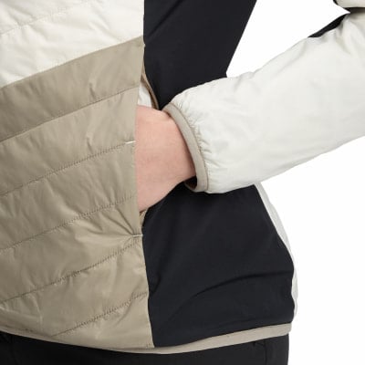 Detail einer Jacke mit Hand in der Tasche, beige und schwarze Einsätze. Detail einer Jacke mit Hand in der Tasche, beige und schwarze Einsätze.