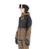 Frau in Skijacke mit Leopardenmuster und Helm.