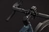 Detail eines Fahrradlenkers mit schwarzem Lenkerband und kleiner Leuchte.