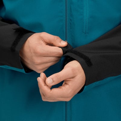 Ein Mann schließt den Klettverschluss am Ärmel seiner Jacke. Ein Mann schließt den Klettverschluss am Ärmel seiner Jacke.