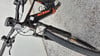 Ein schwarzes KTM E-Bike mit orangefarbenem Logo auf dem Rahmen steht auf dem Boden.