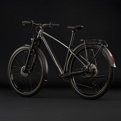 Silbernes Mountainbike mit Schutzblechen und Gepäckträger vor schwarzem Hintergrund. Silbernes Mountainbike mit Schutzblechen und Gepäckträger vor schwarzem Hintergrund.