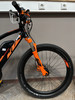 Vorderseite eines schwarzen E-Bikes mit orangefarbenen Akzenten und Federung.