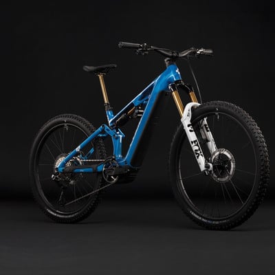Ein blaues E-Mountainbike mit Federung und goldenen Akzenten. Ein blaues E-Mountainbike mit Federung und goldenen Akzenten.