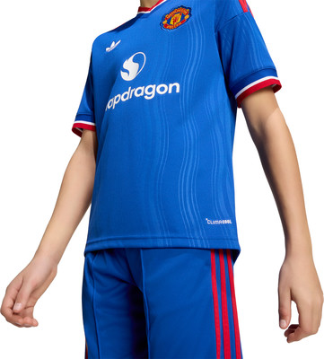 Junge in blauem Manchester United Fußballtrikot mit Snapdragon und Adidas Logo. Junge in blauem Manchester United Fußballtrikot mit Snapdragon und Adidas Logo.