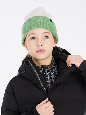 Mädchen in gestreifter Mütze und schwarzer Jacke mit Reißverschluss am Hals.