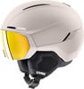Ein beiger Skihelm von Uvex mit integrierter gelber Skibrille.