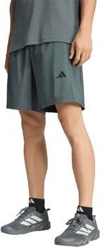 Ein Mann trägt eine dunkelgraue Adidas-Shorts und graue Turnschuhe.
