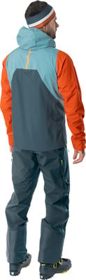 Mann von hinten in Skijacke und Hose mit Mütze.