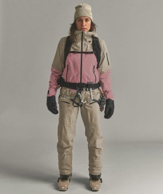 Eine Frau in einer Skijacke, Hose und Skischuhen mit Gurt. Eine Frau in einer Skijacke, Hose und Skischuhen mit Gurt.