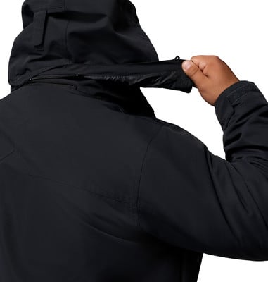Detail eines Mannes, der den Kragen einer schwarzen Kapuzenjacke auf weißem Hintergrund anpasst.