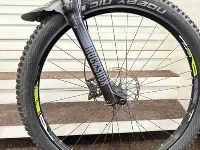 Vorderreifen eines Mountainbikes mit Schutzblech und RockShox-Federung. Vorderreifen eines Mountainbikes mit Schutzblech und RockShox-Federung.