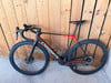 Orbea Rennrad mit Carbonrahmen und schwarzen Laufrädern vor Holzwand.