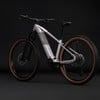 Modernes Cube E-Bike in Grau mit braunen Rädern auf schwarzem Hintergrund.