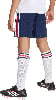Kind in dunkelblauen Shorts mit Streifen, weißen Socken und schwarzen Fußballschuhen.
