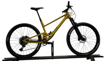 Ein gelbes Mountainbike mit Federung auf einem Ständer.