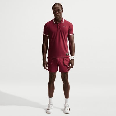 Ein Mann in dunkelroter Tennisbekleidung posiert vor neutralem Hintergrund. Ein Mann in dunkelroter Tennisbekleidung posiert vor neutralem Hintergrund.