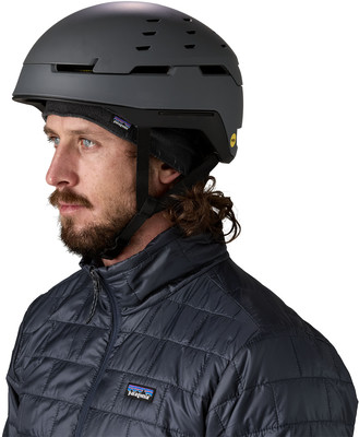 Mann mit grauem Helm und gesteppter Jacke mit Patagonia-Logo. Mann mit grauem Helm und gesteppter Jacke mit Patagonia-Logo.