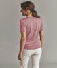 Eine Frau in einem rosa T-Shirt und hellen Hosen steht mit dem Rücken zur Kamera.