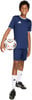 Ein Junge im dunkelblauen Fußballtrikot und Shorts hält einen Ball.