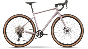 Rosa Gravelbike mit braunen Reifen und schwarzen Komponenten.