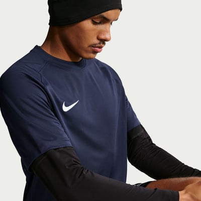 Ein Mann in einem dunkelblauen T-Shirt mit weißem Nike-Logo und schwarzer Mütze. Ein Mann in einem dunkelblauen T-Shirt mit weißem Nike-Logo und schwarzer Mütze.