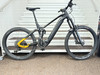 Schwarzes Mountain-E-Bike mit Federung, gelben Details und breiten Reifen.