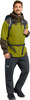 Ein Mann in einer grünen Jacke und schwarzen Hosen mit Rucksack.