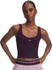 Model in dunkelviolettem Crop-Top und rosafarbener Jogginghose mit Under Armour Logo.